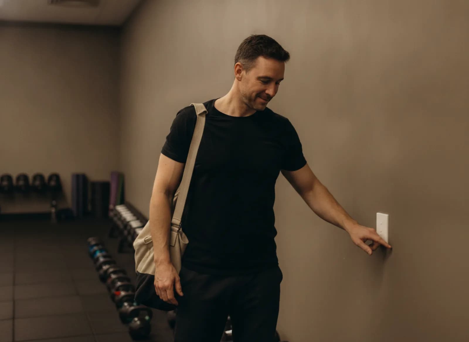 A trainer turning off the lights in the empty gym at night